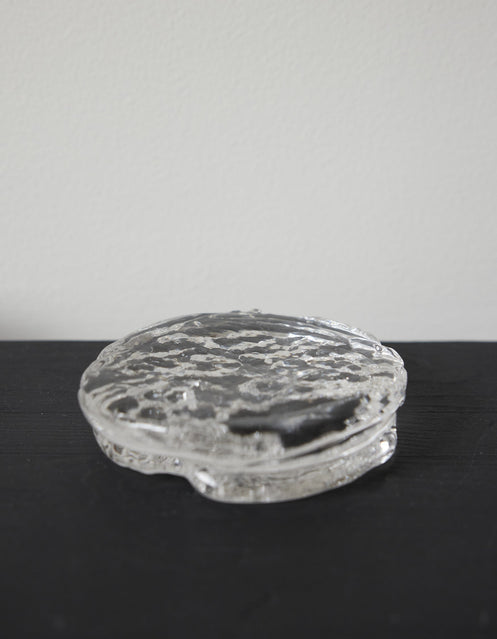 Butter plate | Glass: A small, round, clear-glass container with an ice-textured surface, showcasing Szkło Studio's unique, hand-blown craftsmanship and experimental design approach.