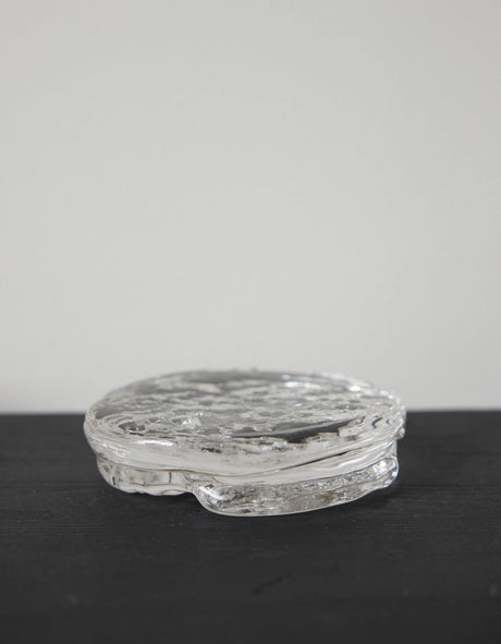 Butter plate | Glass: A small, round, clear-glass container with an ice-textured surface, showcasing Szkło Studio's unique, hand-blown craftsmanship and experimental design approach.