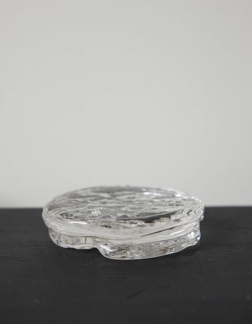 Butter plate | Glass: A small, round, clear-glass container with an ice-textured surface, showcasing Szkło Studio's unique, hand-blown craftsmanship and experimental design approach.