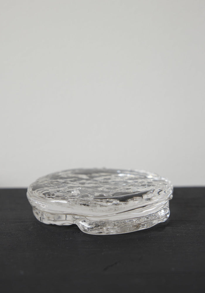 Butter plate | Glass: A clear, disc-shaped glass object with a rippled texture, crafted by Szkło Studio, showcasing unique hand-blown design and functional artistry.