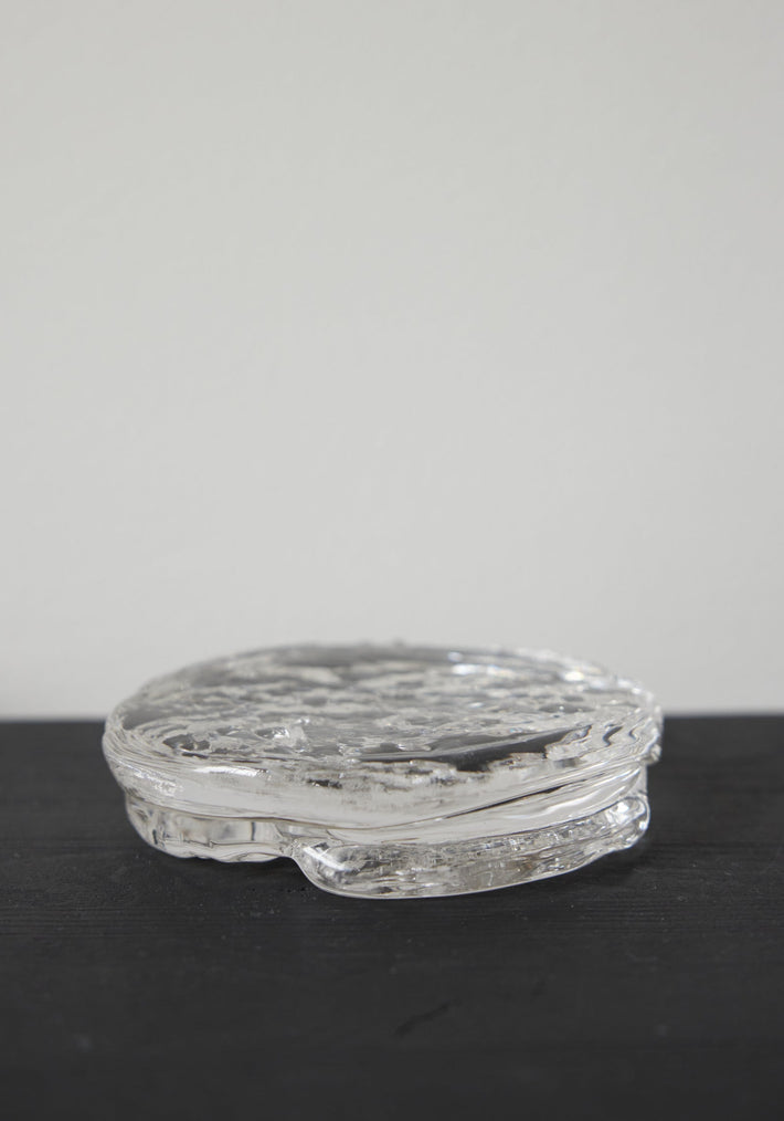 Butter plate | Glass: A clear, disc-shaped glass object with a rippled texture, crafted by Szkło Studio, showcasing unique hand-blown design and functional artistry.