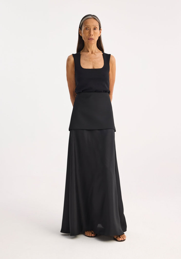 Woman wearing a Bustier shaped knitted top with a fitted, square neckline, and layered panels, paired with a flowing skirt. Model height: 1.72m, size EU 36.