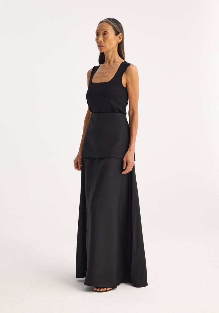 Bustier shaped knitted top in black, featuring a fitted, sleeveless design with a scoop-neck, worn by a model with long straight hair, arms relaxed.