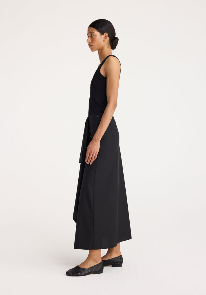 Woman wearing Bustier shaped knitted top with a fitted silhouette, bustier neckline, paired with an ankle-length skirt and woven-textured flats.