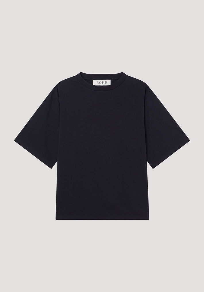 Oversized cotton t-shirt by RÓHE, featuring a plain black design with crew neck, short sleeves, and brand label at the collar, laid flat.
