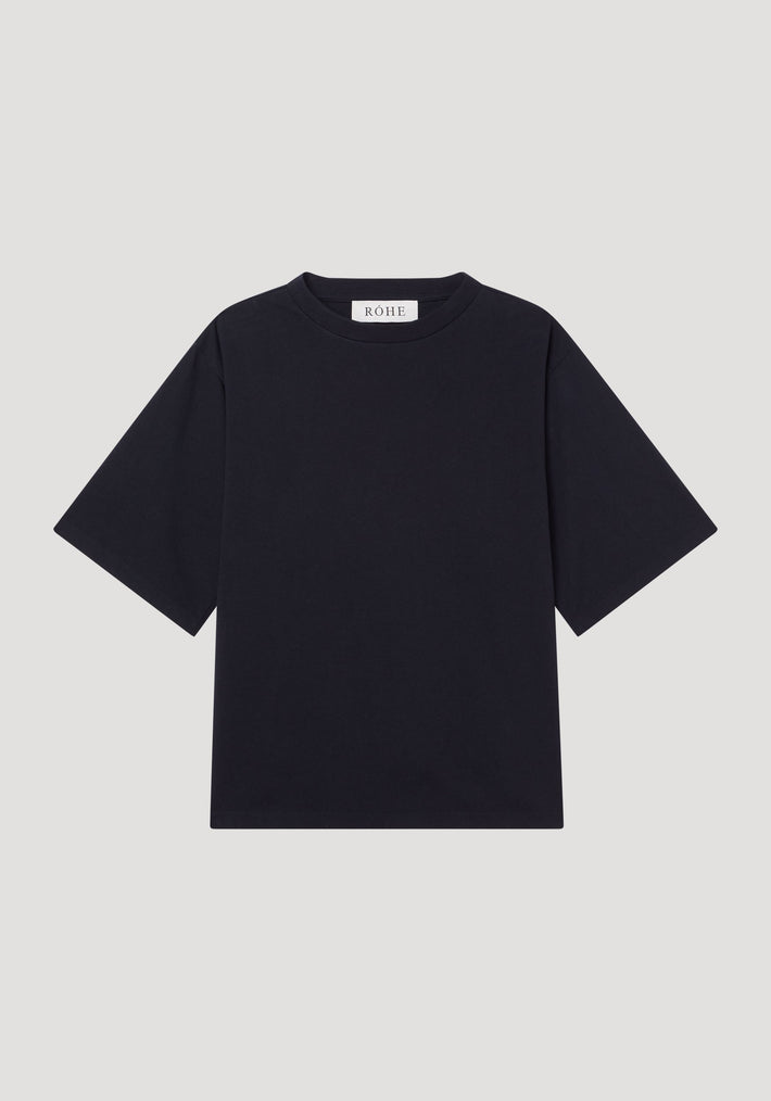Oversized cotton t-shirt in black, featuring a boxy fit, crew neck, drop shoulders, and a small RÓHE label at the back neckline. Made from organic cotton.