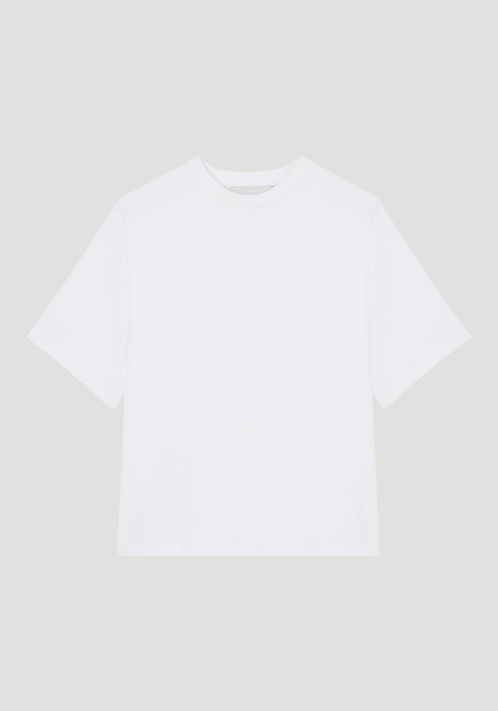 Oversized cotton t-shirt in optic white, featuring a relaxed fit with drop shoulders and crew neck, displayed flat with a small logo label on the sleeve.