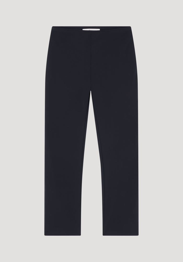 Cigarette scuba trousers in heavyweight black fabric, showcasing a slim-leg design and elastic waistband, laid flat against a light gray background.