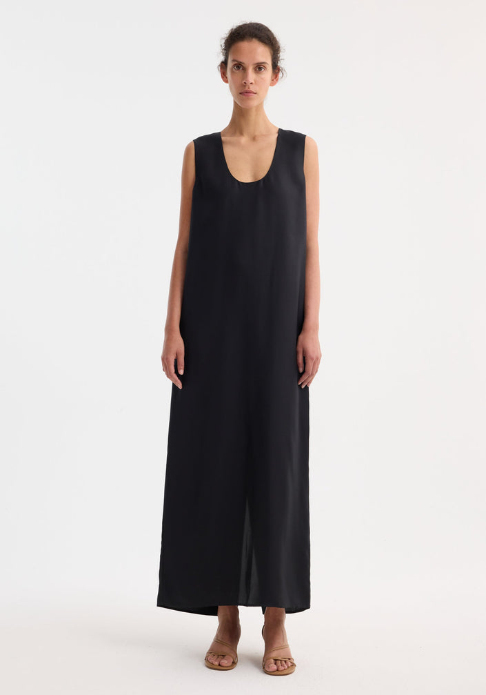 Scoop-neck silk dress | black: Sleeveless, floor-length black dress with a relaxed tank-style silhouette and deep scoop neckline, made from luxurious 100% silk, labeled “RÓHE.”