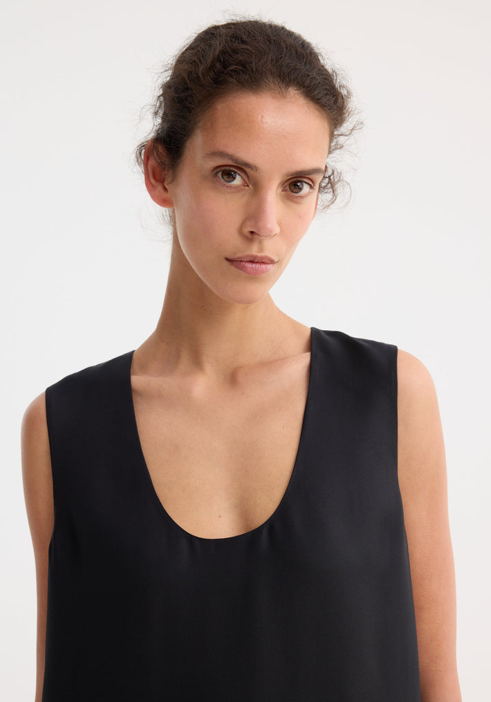 Model wearing a sleeveless black scoop-neck silk top, showcasing the upper design of the floor-length Scoop-neck silk dress for a timeless, elegant look.
