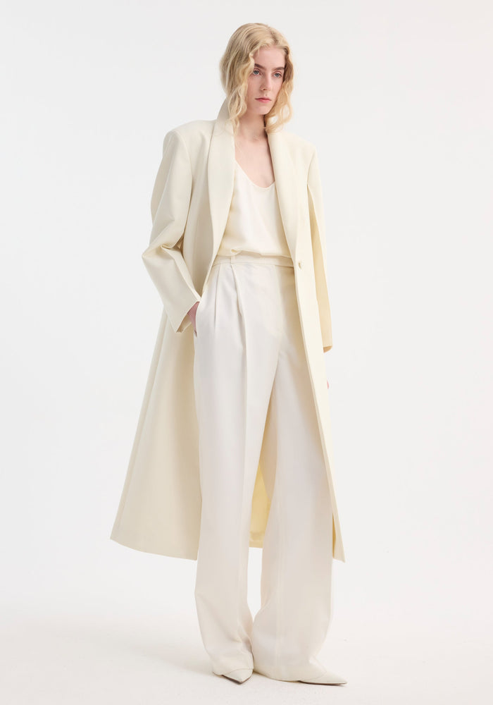 Model in a Signature opera coat | ivory, showcasing a tailored fit with a single-button closure, softly structured shoulders, and a relaxed, minimalist pose.