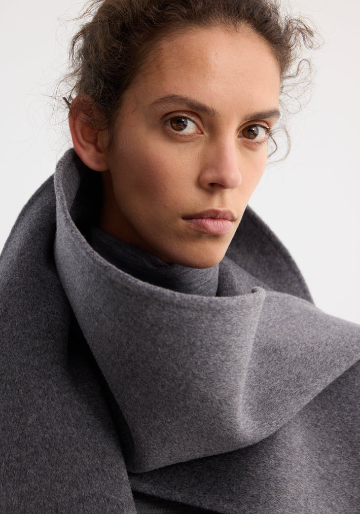 Young woman wearing the Signature double-faced scarf coat in mid grey melange, featuring an oversized, double-layered scarf collar, crafted from a wool-cashmere blend.