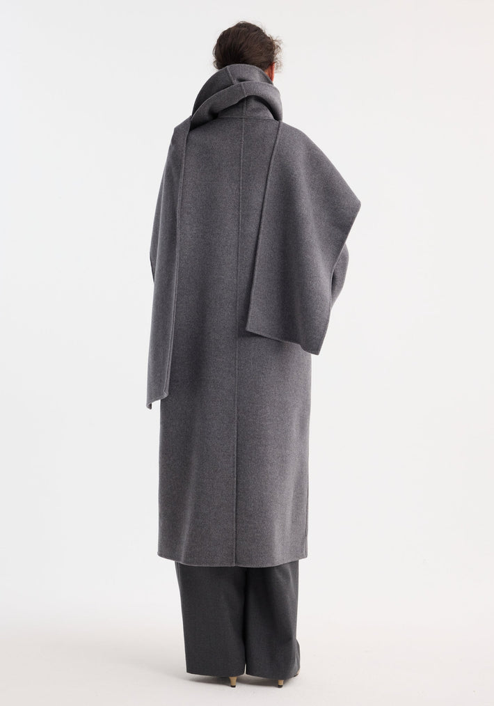 Signature double-faced scarf coat in mid grey melange, featuring a double-layered scarf collar, worn over wide-leg trousers and neutral pointed-toe heels, seen from behind.