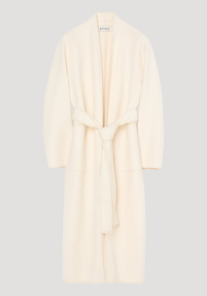 Double-faced kimono style coat in off white, featuring a calf-length wrap design with patch pockets, long sleeves, and a self-tie belt for an adjustable fit.