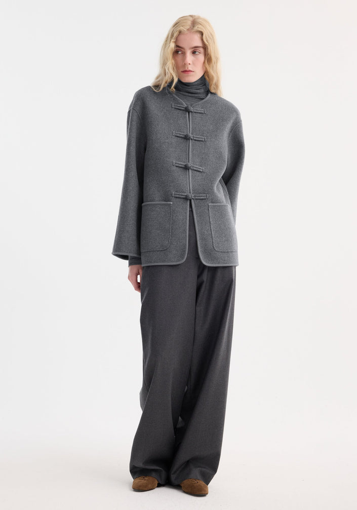 Mandarin double-faced wool jacket in mid grey melange with four frog closures, embroidered edges, patch pockets, and a simple rounded neckline, labeled RÓHE.