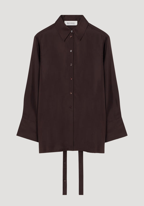 Deconstructed silk shirt in mahogany with an open back, pointed collar, and fabric ties for styling versatility, featuring a RÓHE label inside.