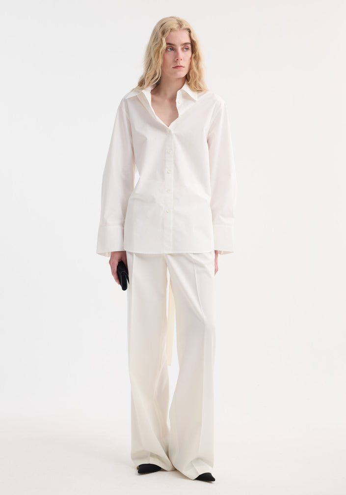 Poplin silk combined gilet-shirt by RÖHE, featuring a button-down front, collared neckline, long sleeves knotted at waist, and silk back with open armholes.