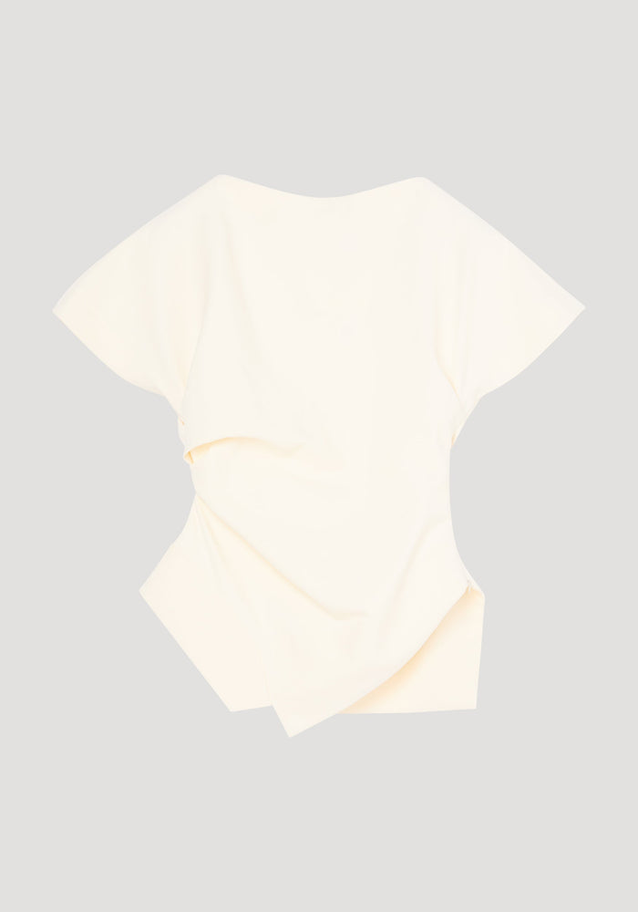 Draped lapel top in off-white with sculptural asymmetrical silhouette; features wide sleeves, scooped neckline, and overlapping fabric panels for a modern, architectural look.