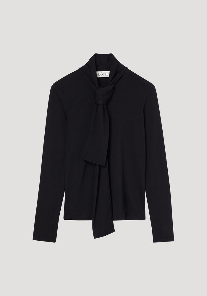 Merino scarf top | black: Women's fitted black long-sleeve turtleneck with an elegant scarf-style tie at the neckline, crafted from pure merino wool. RÖHE label visible.