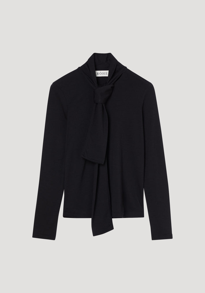 Merino scarf top | black: Women's fitted black long-sleeve turtleneck with an elegant scarf-style tie at the neckline, crafted from pure merino wool. RÖHE label visible.