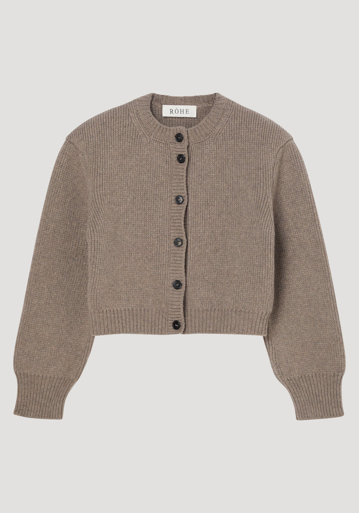 Statement shoulder cardigan in clay melange, featuring a ribbed knit, oversized fit, sculptural shoulders, dark button closure, and round neckline. Crafted from Italian pure wool.