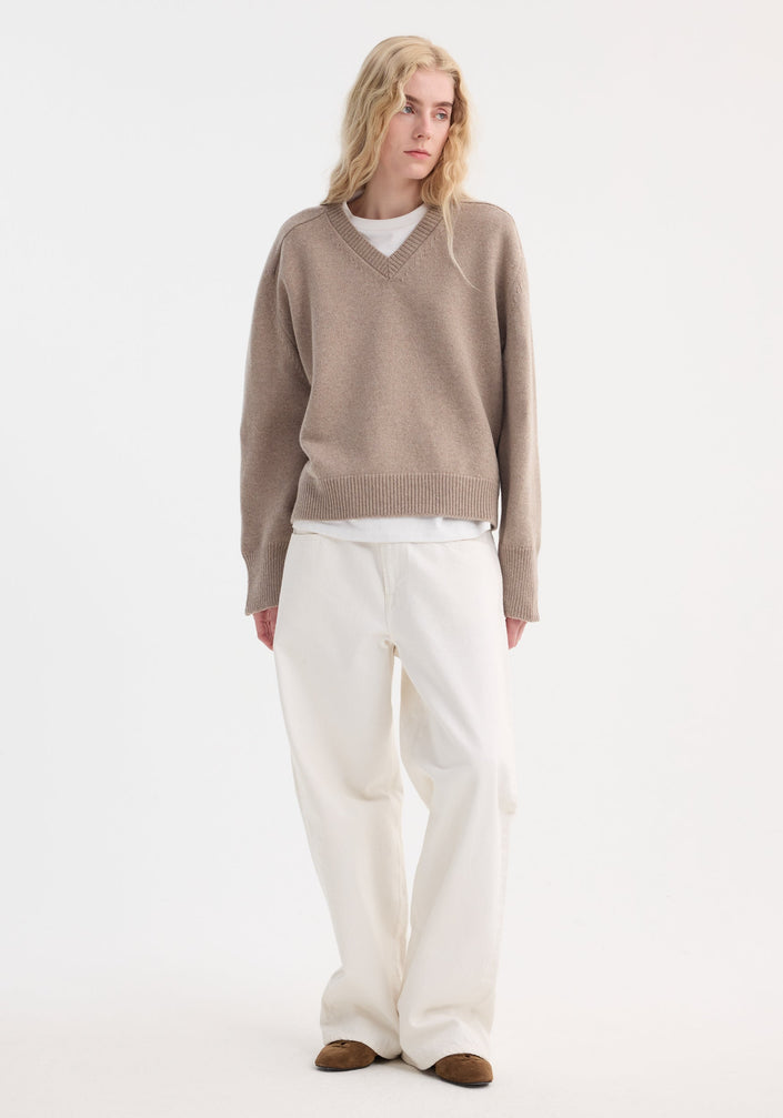 Sleeve wrap jumper in taupe melange, showing V-neck, ribbed cuffs and hem, relaxed fit. Crafted from a cashmere-wool blend, features twistable sleeves for versatile styling.