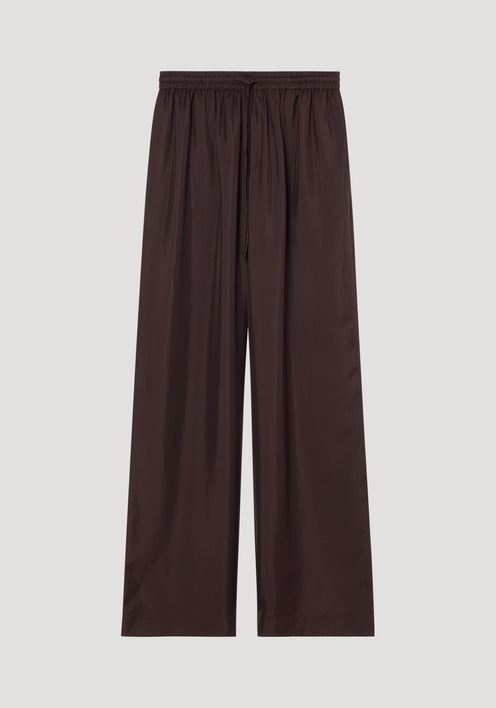 Wide leg silk trousers in mahogany with elastic waistband and drawstring, crafted from pure silk with a twill structure, laid flat showcasing wide-leg design.