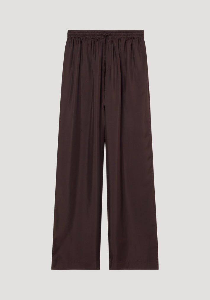 Wide leg silk trousers in mahogany with elastic waistband and drawstring, crafted from pure silk with a twill structure, laid flat showcasing wide-leg design.