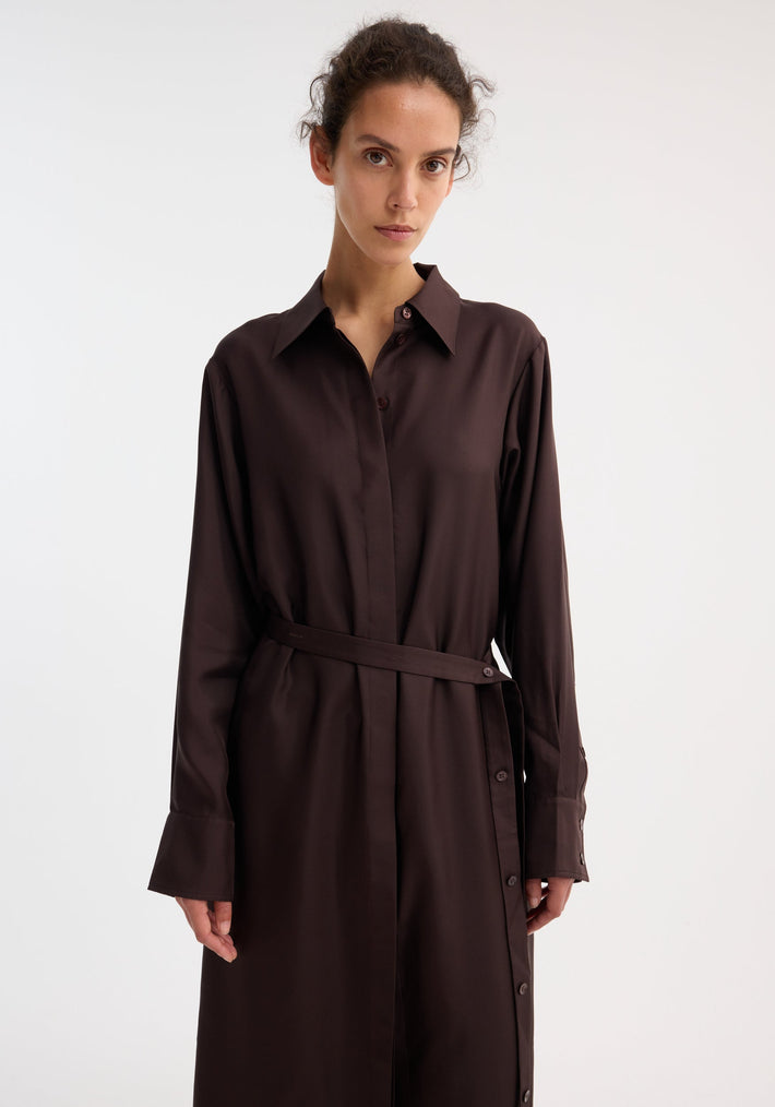 Silk open back wrap dress in mahogany, featuring a button-up front, matching belt, and keyhole back, modeled by a slim woman with dark hair.