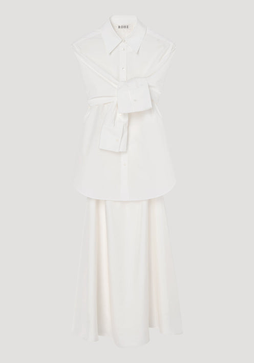 Poplin silk combined gilet-dress in optic white, featuring a deconstructed design with open armholes, buttoned wrap belt, and a fluid silk skirt.