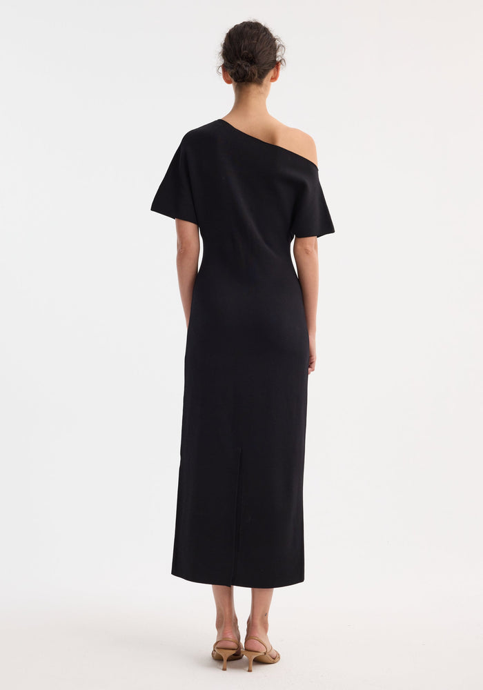 Back view of Asymmetrical knitted dress | black, showcasing refined tailoring and elevated minimalism. Features sculptural design, crafted with Italian fabrics, embodying quiet confidence and timeless, intentional craftsmanship.