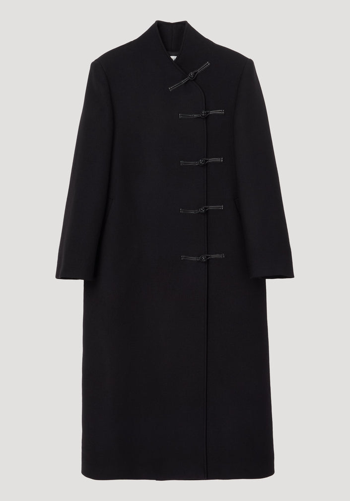 Mandarin wool coat in black featuring asymmetric mandarin closures, long length, side pockets, crafted from 100% virgin wool with a minimalist, straight silhouette.