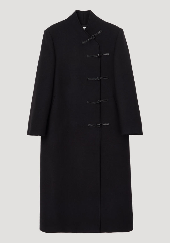 Mandarin wool coat in black featuring asymmetric mandarin closures, long length, side pockets, crafted from 100% virgin wool with a minimalist, straight silhouette.