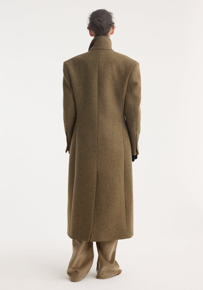 Hourglass wool coat in forest melange, showcasing a tailored fit with strong shoulders and feminine waist, worn over wide-leg trousers, viewed from the back.