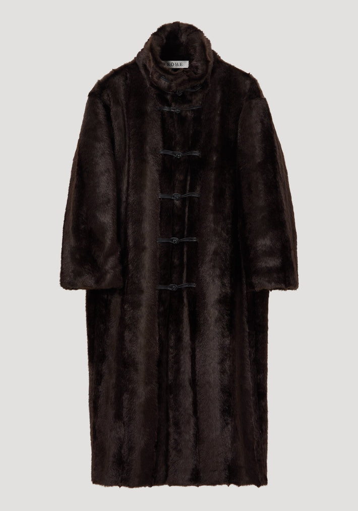 Mandarin faux fur coat in dark brown with a full-length design, stand-up collar, and five toggle-style closures, modeled in an oversized fit.
