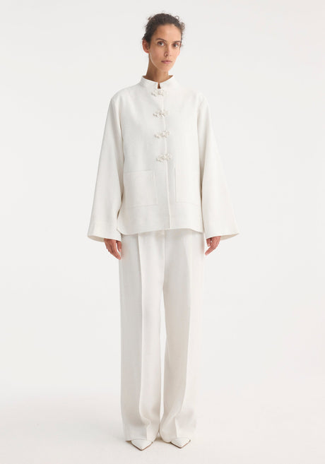 Mandarin jacket in winter white with pankou closures, square patch pockets, light silk-blend fabric, and wide sleeves; model is 179cm, wearing size EU 36.