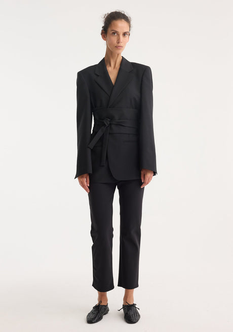 Kimono belted blazer in black, featuring a wrap-style design with notch lapels, wide sash tie, and tailored hourglass silhouette, crafted from wool-mohair blend.