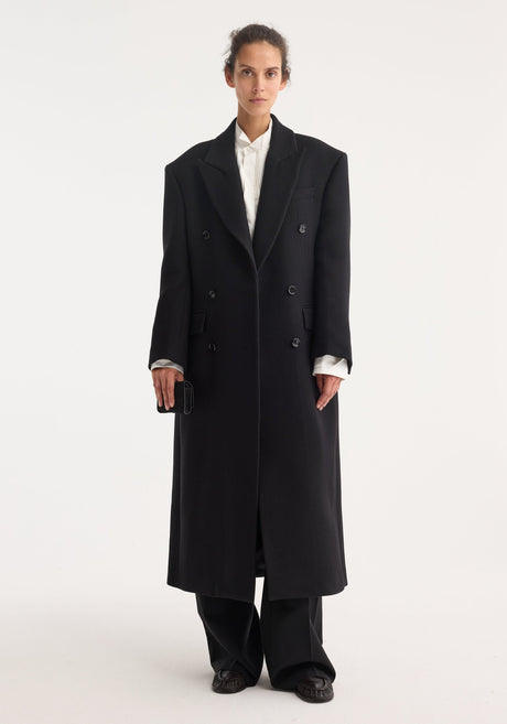 Hourglass wool coat | black, featuring a long, double-breasted design with six buttons, structured shoulders, and a feminine waist. Made from 100% virgin wool.