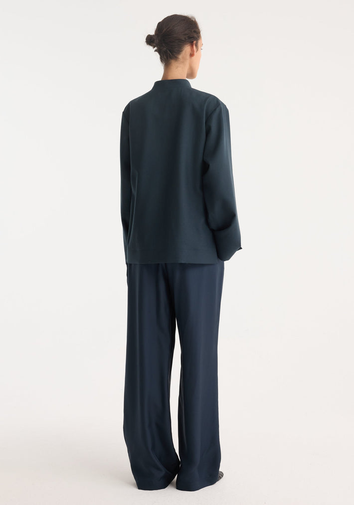 Back view of a person wearing the Mandarin jacket | storm, featuring wide sleeves, traditional pankou closures, and patch pockets, with loose-fit, wide-leg trousers.