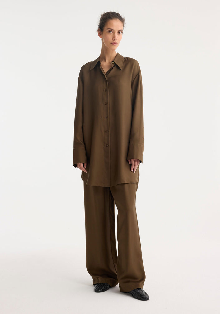 Signature elongated silk shirt | forest, featuring a rich chocolate-brown hue, oversized fit, pointed collar, button-down front, and simple cuffs. Crafted from 100% silk for elegance.