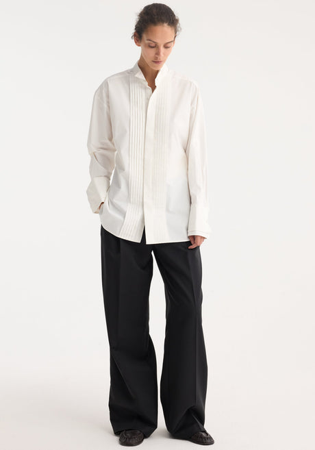 Tuxedo wired shaped shirt in optic white, featuring a hidden placket, vertical pintucks, stand collar, and statement cuffs, crafted from 100% cotton.