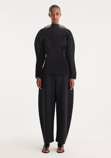 Sculptural plissé top | black: Women’s black long-sleeve top with finely pleated fabric, scooped neckline, slim fit, and voluminous sleeves, from label “RÖHE.”