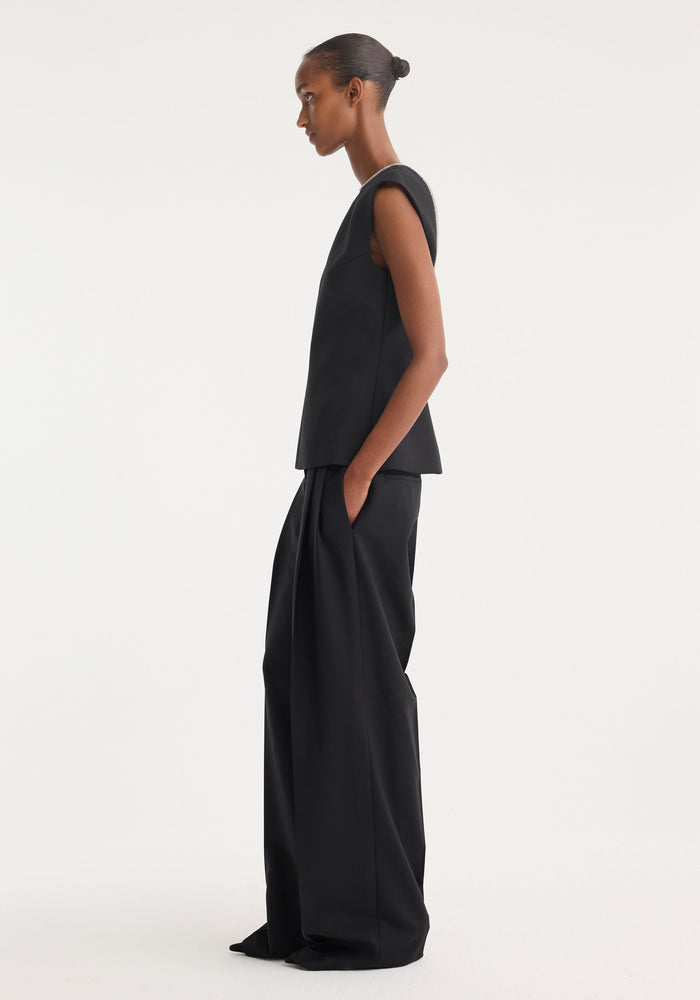Open back appliqué top in black, featuring a sleeveless, structured design, wide-leg trousers, crystal appliqué on open back, and front seam detail.