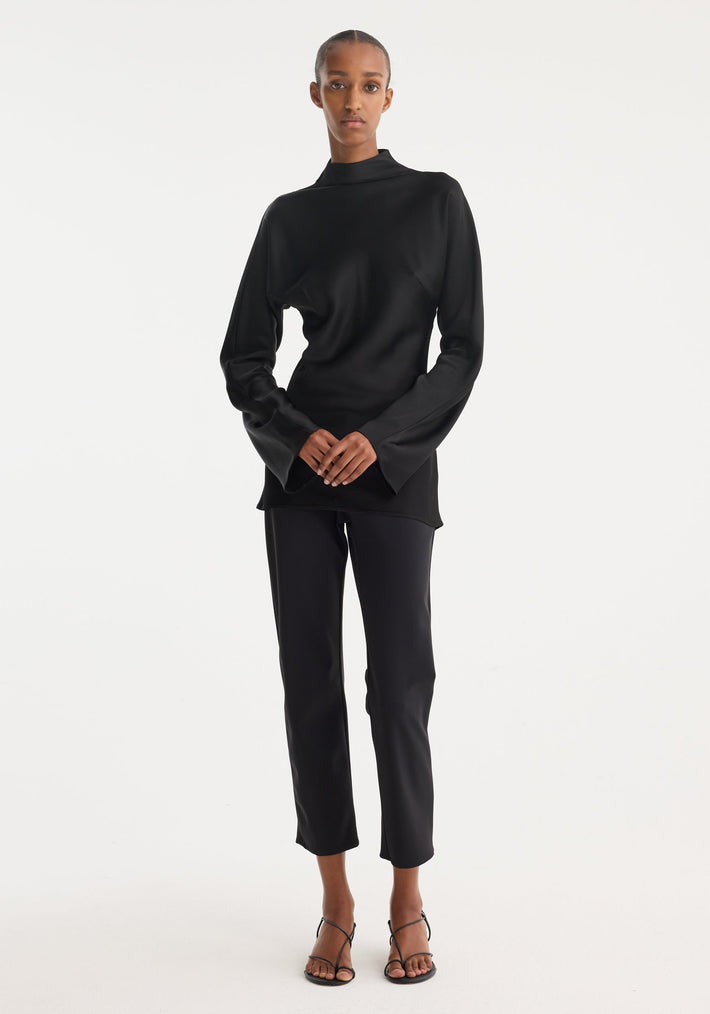Model wearing a Satin waisted top | black, featuring a mock neck, long flared sleeves, and a slim-fit design with a seamless back zip closure.