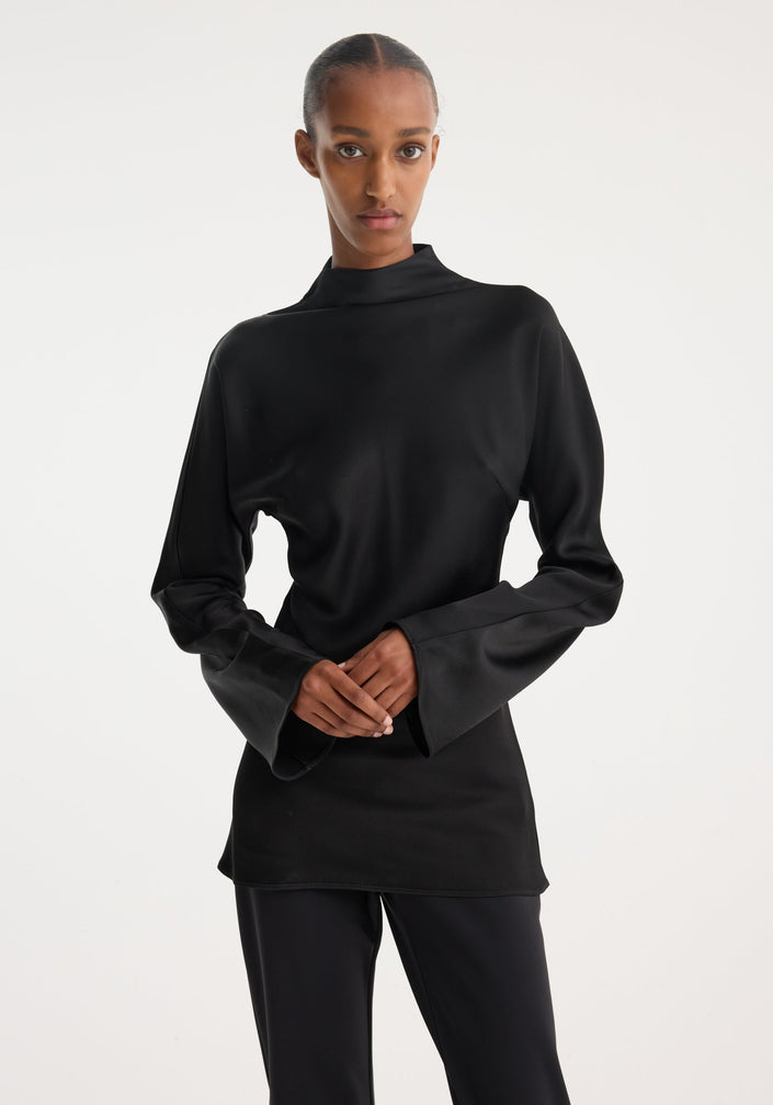 Model wearing a Satin waisted top | black, featuring a mock neck, long flared sleeves, and a slim-fit design with a seamless back zip closure.