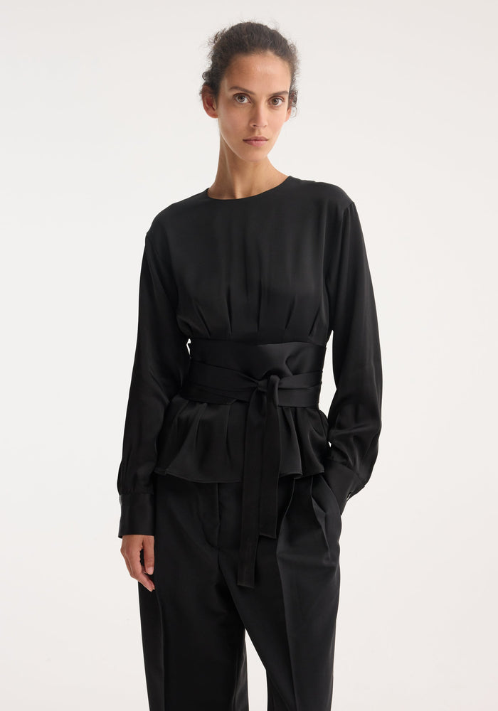 Kimono satin top in black, featuring a round neckline and long sleeves, cinched at the waist with a wide, wrap-around sash.
