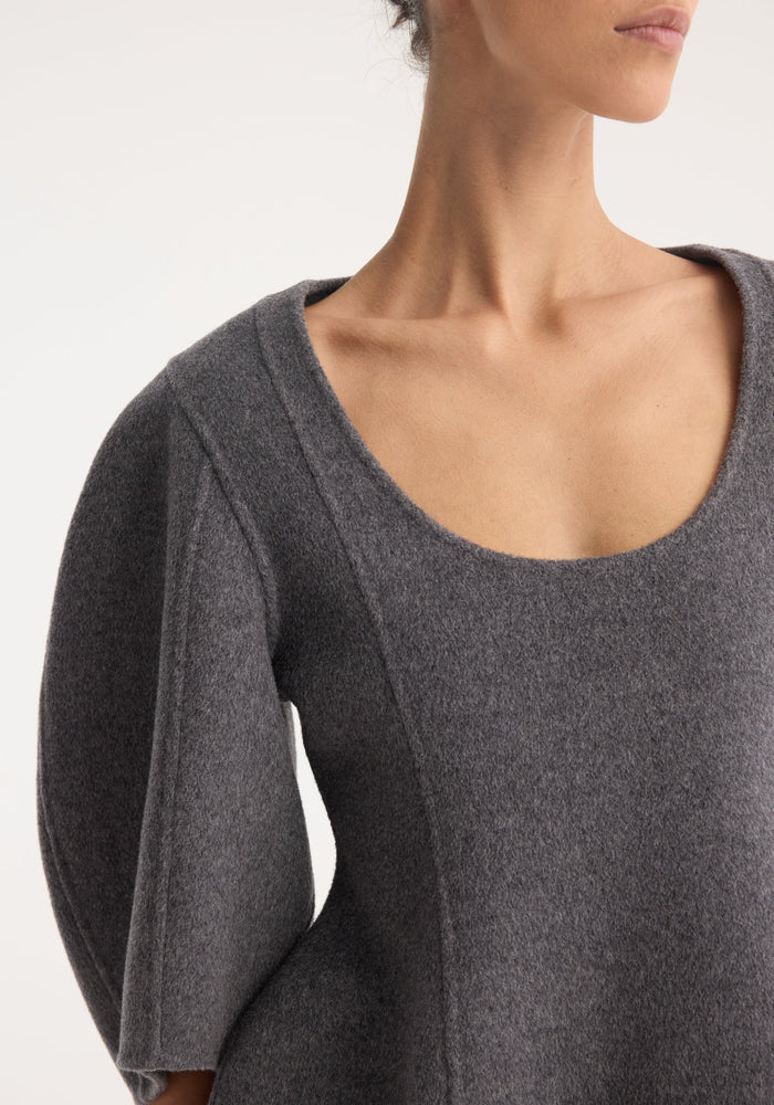 A model wears the Sculptural double-faced top in mid grey melange, featuring a scoop neckline, elbow-length balloon sleeves, and a structured peplum silhouette.