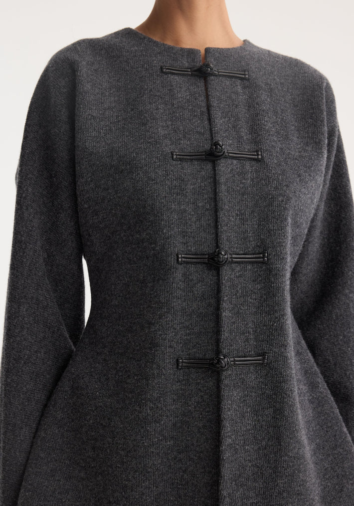 Mandarin waisted cardigan in mid grey melange with black frog closures, cinched waist, long sleeves, round neckline, showcasing a sculptural, artisanal design.