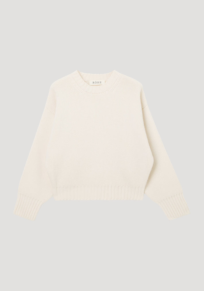 Sculptural compact crewneck | off white: Cream knit sweater with a crew neckline, dropped shoulders, ribbed cuffs, and hem, laid flat. Made of 100% wool by Italian artisans.