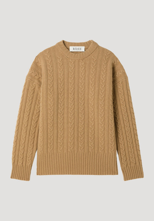 Cable knit jumper in camel with oversized fit, featuring a crew neck, long sleeves, and a cable-knit texture. Label reads “RÓHE” at the back.